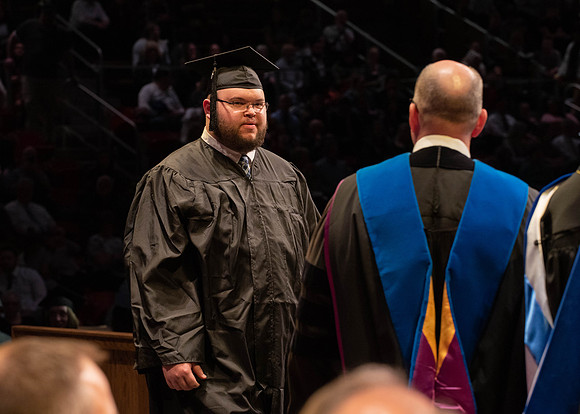 Students graduate and walk to receive their diplomas during convocation in the College of Physical Sciences and Engineering.