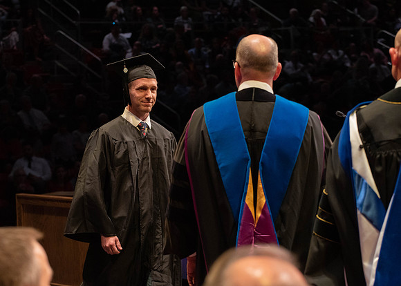 Students graduate and walk to receive their diplomas during convocation in the College of Physical Sciences and Engineering.
