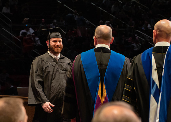 Students graduate and walk to receive their diplomas during convocation in the College of Physical Sciences and Engineering.