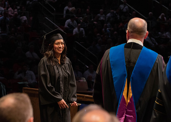 Students graduate and walk to receive their diplomas during convocation in the College of Physical Sciences and Engineering.
