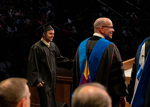 Students graduate and walk to receive their diplomas during convocation in the College of Physical Sciences and Engineering.