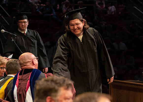 Students graduate and walk to receive their diplomas during convocation in the College of Physical Sciences and Engineering.