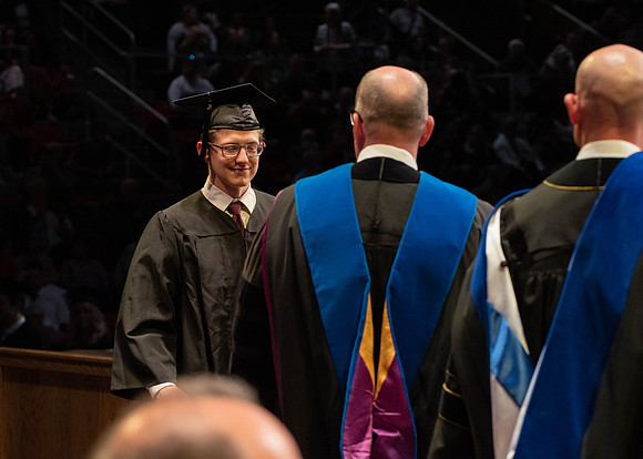 Students graduate and walk to receive their diplomas during convocation in the College of Physical Sciences and Engineering.