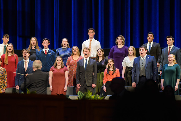 Elder Kyle S. McKay address students of BYU-Idaho in the I-Center. Other students and Henry J. Eyring assist in the Devotional.