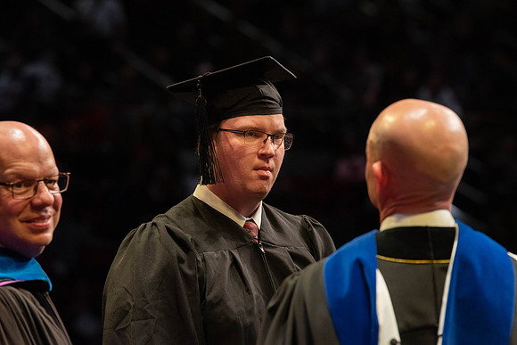 Students graduate and walk to receive their diplomas during convocation in the College of Physical Sciences and Engineering.