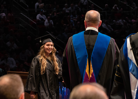 Students graduate and walk to receive their diplomas during convocation in the College of Physical Sciences and Engineering.