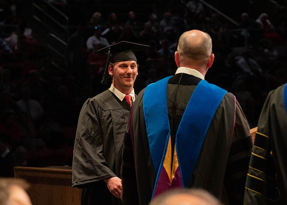 Students graduate and walk to receive their diplomas during convocation in the College of Physical Sciences and Engineering.