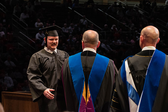 Students graduate and walk to receive their diplomas during convocation in the College of Physical Sciences and Engineering.