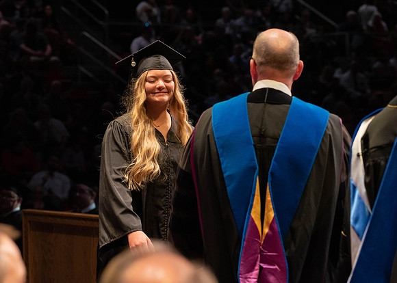 Students graduate and walk to receive their diplomas during convocation in the College of Physical Sciences and Engineering.