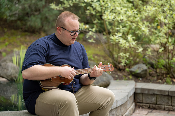 Thommy Oaks enjoying a little freetime in the gardens while playing the ukulele.