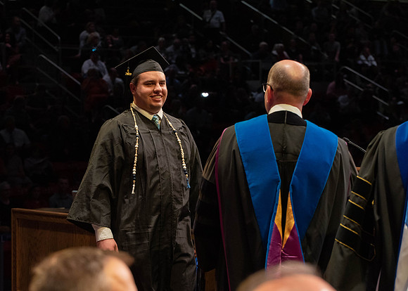 Students graduate and walk to receive their diplomas during convocation in the College of Physical Sciences and Engineering.
