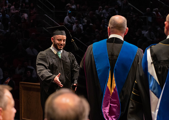 Students graduate and walk to receive their diplomas during convocation in the College of Physical Sciences and Engineering.