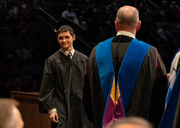 Students graduate and walk to receive their diplomas during convocation in the College of Physical Sciences and Engineering.