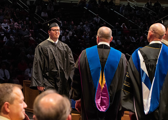 Students graduate and walk to receive their diplomas during convocation in the College of Physical Sciences and Engineering.