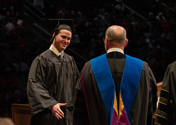 Students graduate and walk to receive their diplomas during convocation in the College of Physical Sciences and Engineering.