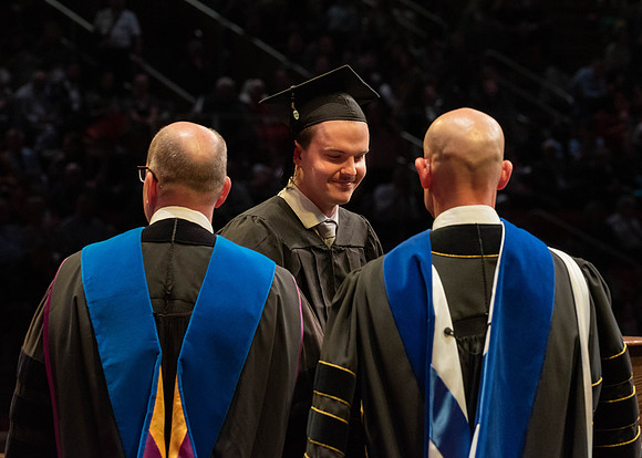 Students graduate and walk to receive their diplomas during convocation in the College of Physical Sciences and Engineering.