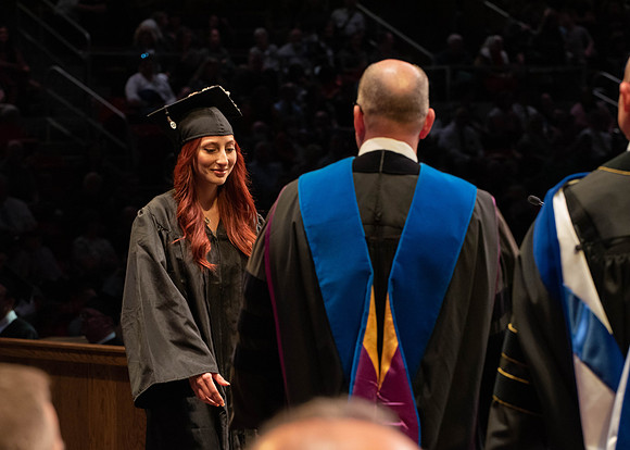 Students graduate and walk to receive their diplomas during convocation in the College of Physical Sciences and Engineering.