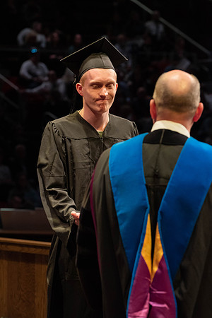Students graduate and walk to receive their diplomas during convocation in the College of Physical Sciences and Engineering.