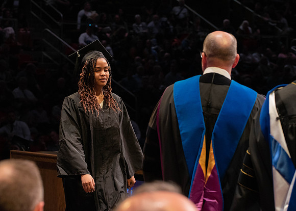 Students graduate and walk to receive their diplomas during convocation in the College of Physical Sciences and Engineering.