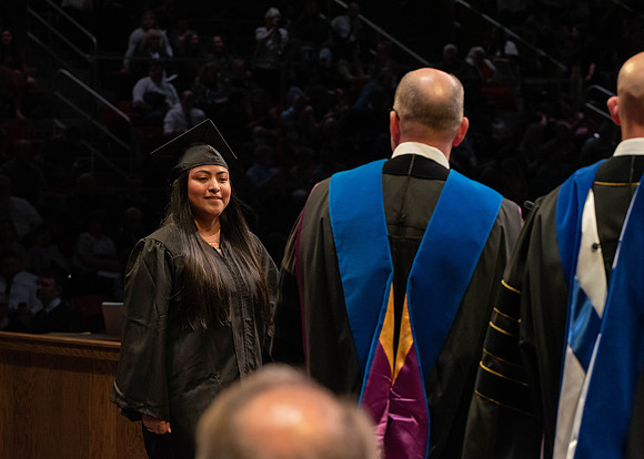 Students graduate and walk to receive their diplomas during convocation in the College of Physical Sciences and Engineering.