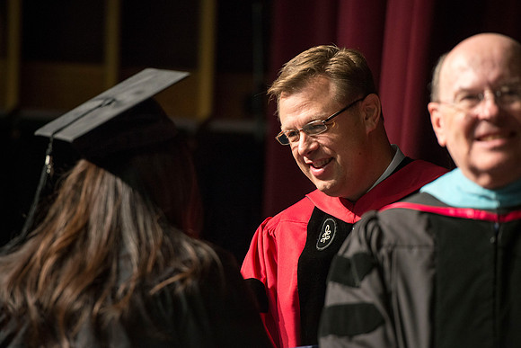 President Gilbert shakes hands with a graduate during convocation.