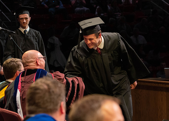 Students graduate and walk to receive their diplomas during convocation in the College of Physical Sciences and Engineering.