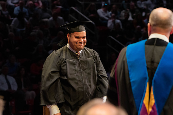 Students graduate and walk to receive their diplomas during convocation in the College of Physical Sciences and Engineering.