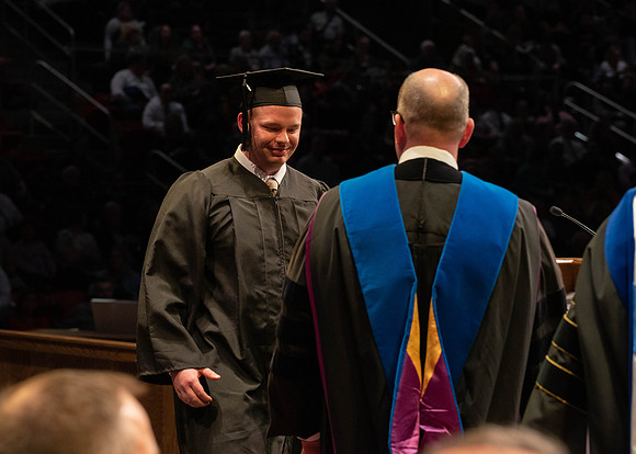 Students graduate and walk to receive their diplomas during convocation in the College of Physical Sciences and Engineering.