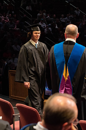 Students graduate and walk to receive their diplomas during convocation in the College of Physical Sciences and Engineering.