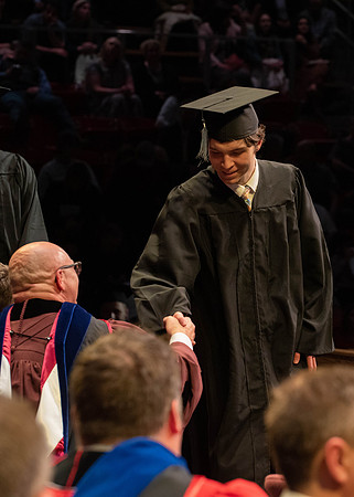 Students graduate and walk to receive their diplomas during convocation in the College of Physical Sciences and Engineering.
