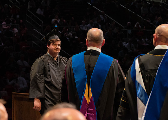 Students graduate and walk to receive their diplomas during convocation in the College of Physical Sciences and Engineering.