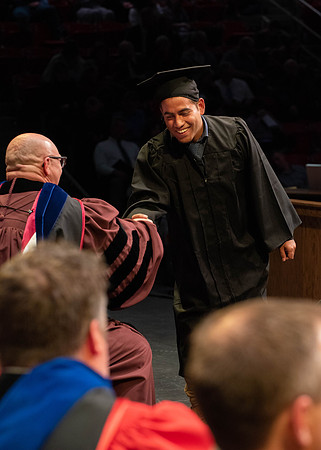 Students graduate and walk to receive their diplomas during convocation in the College of Physical Sciences and Engineering.