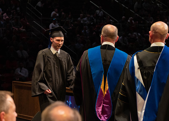 Students graduate and walk to receive their diplomas during convocation in the College of Physical Sciences and Engineering.