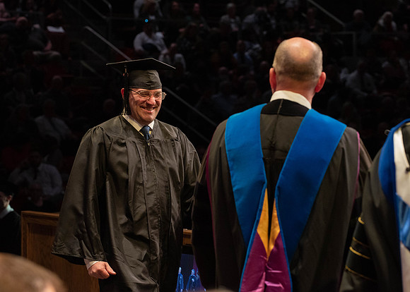 Students graduate and walk to receive their diplomas during convocation in the College of Physical Sciences and Engineering.