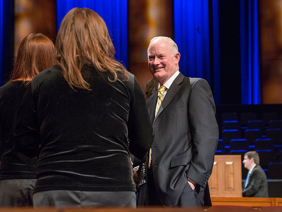 President Kim B. Clark, President of BYU-Idaho and Elder Dallin H. Oaks, Quorum of the Twelve Apostles shake hands with students at Brigham Young University-Idaho. Other students await their turn for