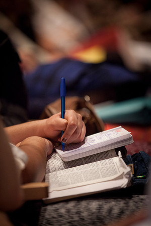 A student takes notes during Devotional.