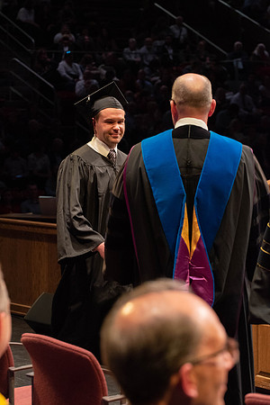 Students graduate and walk to receive their diplomas during convocation in the College of Physical Sciences and Engineering.