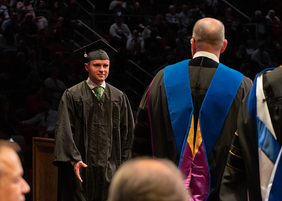 Students graduate and walk to receive their diplomas during convocation in the College of Physical Sciences and Engineering.