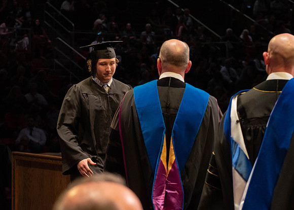 Students graduate and walk to receive their diplomas during convocation in the College of Physical Sciences and Engineering.