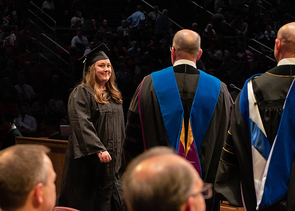 Students graduate and walk to receive their diplomas during convocation in the College of Physical Sciences and Engineering.