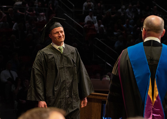 Students graduate and walk to receive their diplomas during convocation in the College of Physical Sciences and Engineering.
