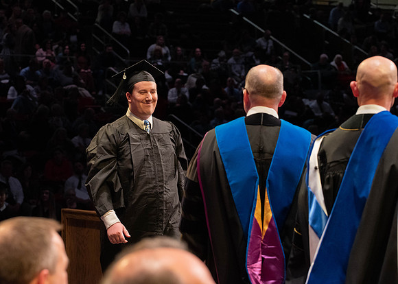 Students graduate and walk to receive their diplomas during convocation in the College of Physical Sciences and Engineering.
