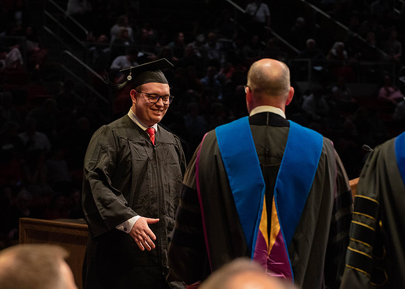 Students graduate and walk to receive their diplomas during convocation in the College of Physical Sciences and Engineering.