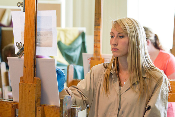 A student in Brother Bodily's Painting class concentrates on painting her landscape during class in the 2014 Spring Semester in the Spori Building.