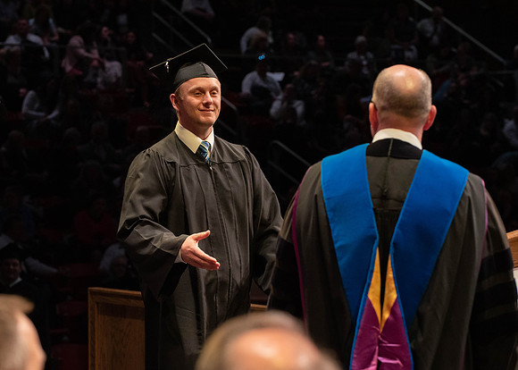 Students graduate and walk to receive their diplomas during convocation in the College of Physical Sciences and Engineering.