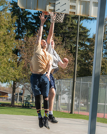 Jacob Kaiser (in yellow) playing basketball, one on one with Jacob Madsen at Smith Park in Rexburg, Idaho.