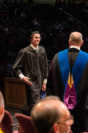 Students graduate and walk to receive their diplomas during convocation in the College of Physical Sciences and Engineering.
