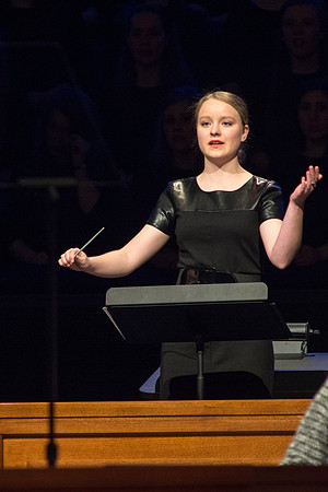A student conducts the music at devotional.
