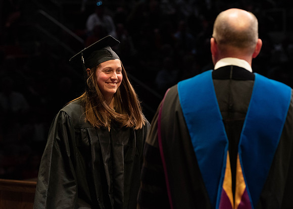 Students graduate and walk to receive their diplomas during convocation in the College of Physical Sciences and Engineering.