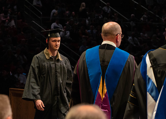 Students graduate and walk to receive their diplomas during convocation in the College of Physical Sciences and Engineering.